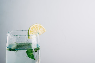 Refreshing drink with lime. Homemade mojito on summer wooden table surrounded by limes, peppermint and sugar. Copyspace