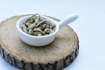 Dry cardamom seed (Elettaria cardamomum) displayed in containers