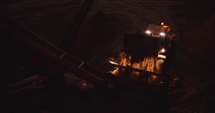 Front loader truck transports ground to the stone crusher at construction site