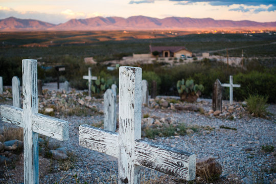 Two wooden cross grave markers overlooking sunset over hills in Boothill graveyard in Tombstone