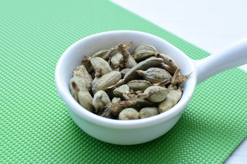 Dry cardamom seed (Elettaria cardamomum) displayed in containers