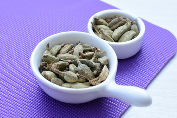 Dry cardamom seed (Elettaria cardamomum) displayed in containers