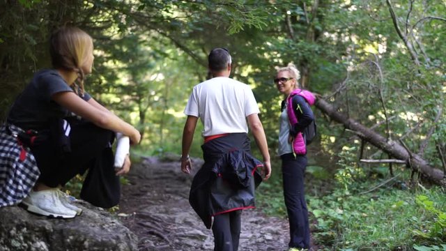 Family Hiking in Mountains. Girl with broken arm shows strenght and courage.