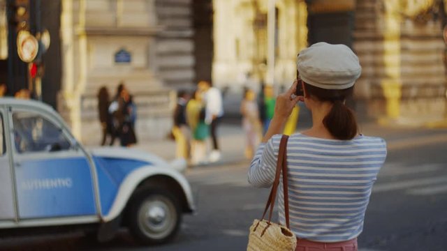 Young tourist taking photo of retro car in Paris