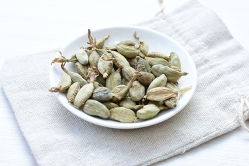 Dry cardamom seed (Elettaria cardamomum) displayed in containers