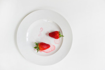 two red strawberry on white plate background