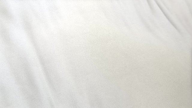 white flag cloth in full frame with selective focus. Seamlessly looping 3D animation of slight off white garment with clean natural linen texture for background banner or wallpaper use.
