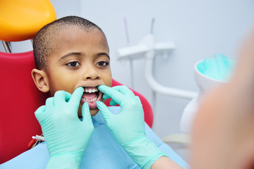 little cute black baby boy African American sitting in dental chair. Pediatric dentistry