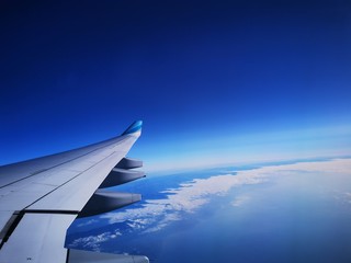 Obraz premium wing of an airplane flying above clouds