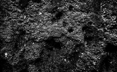 Surface of stone rock as black grainy noisy grungy texture background backdrop