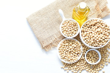 Fototapeta na wymiar Raw soybeans (Glycine max) displayed in containers and accompanied by oil