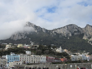 View of the coast and port of Capri, Italy on a sunny but cloudy day 