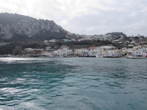 View of the coast and port of Capri, Italy on a sunny but cloudy day 