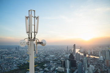 Telecommunication tower with 5G cellular network antenna on city background