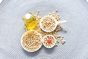 Raw soybeans (Glycine max) displayed in containers and accompanied by oil