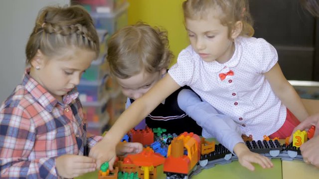 Children in the classroom make figures with teacher. Modern technology concept