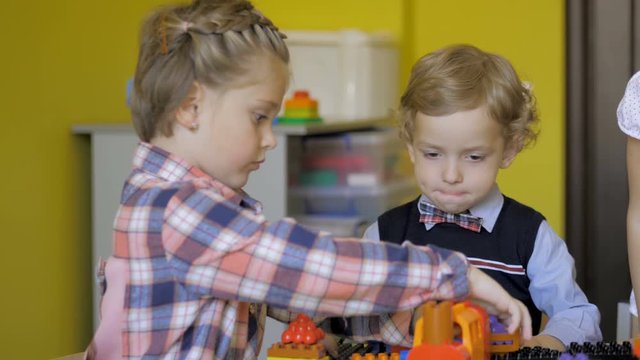Children in the classroom make figures with teacher. Modern technology concept