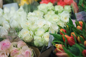 Bright fresh spring flowers tulips on the counter of a flower shop in the market. Beautiful gift for a girl or beloved woman. Soft focus and beautiful bokeh.
