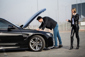 Obraz premium Man with broken car in the middle of the road.