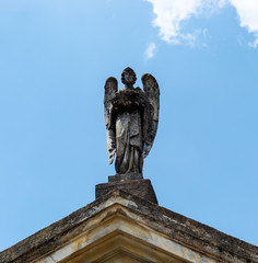 An Angel Loooking serenity in sunny day. This sculpture decorate de facade of an old mausoleum into...