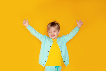 The concept of a good mood. Positive vibes. Totally satisfied with Shopping Day. I feel cool. Cute boy 5-6 years old on a yellow background.