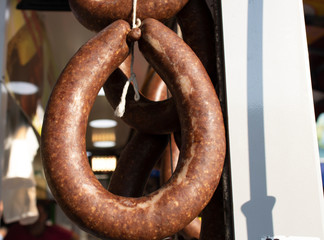Naklejka premium Turkish style sausage close-up. It is drying outside. Suspended from above.