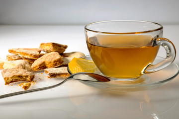 Cookies and a cup of tea on a saucer, on a white background. Light breakfast