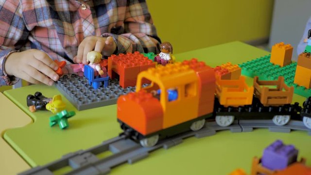 Children in the classroom make figures with teacher. Modern technology concept