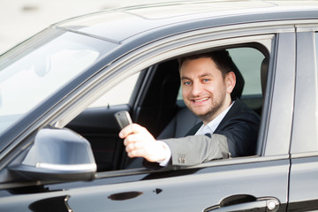 Young happy man bought new modern car