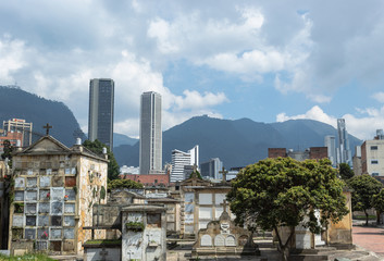 Modern skyscrapers with Central Cemetery builded in 1836 in downtown bogota city.  Monserrate and Guadalupe mountains at background