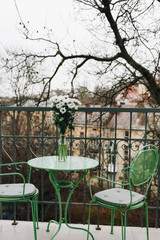 Cozy balcony with green table and chairs 