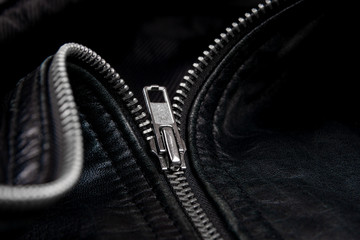 Iron zipper on a black leather jacket, needlework concept.