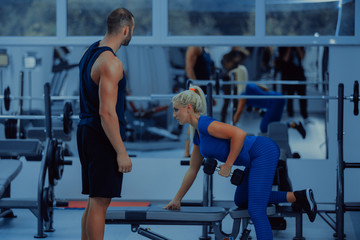 Fototapeta na wymiar Fitness instructor with girl on training in fitness center