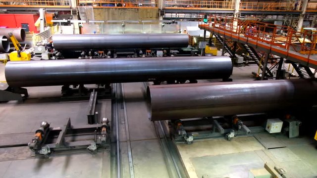 Pipe factory production line, pipes moving on roller conveyor