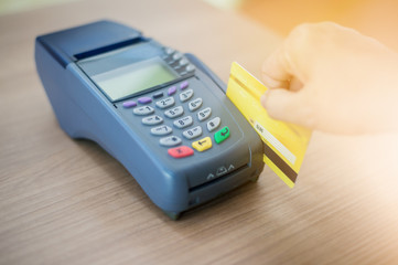 Hand Swiping Credit Card moment in-store of payment buy and sell products & service. Credit Card swipe machine.