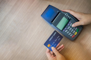 Hand Swiping Credit Card moment in-store of payment buy and sell products & service. Credit Card swipe machine.