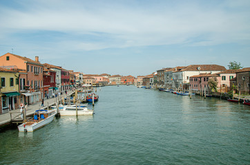 Fototapeta na wymiar Venice, Italy May 18, 2015: View of beautiful canals and boats docked alongside the walkways in Venice Italy