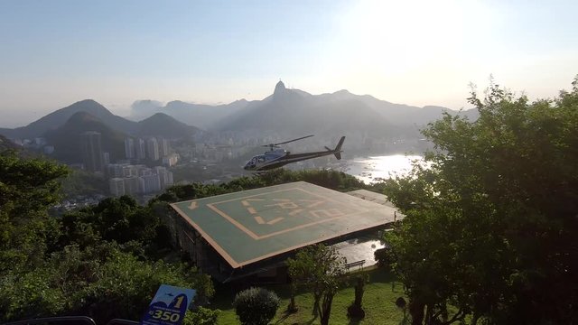 Rio De Janeiro helicopter take off. Helicopter ascending from helipad at the top of Sugarloaf Mountain. Panoramic view of Brazil with famous beach background. Aerial cityscape. Scenic travel.