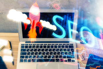Multi exposure of table with computer and seo drawing hologram. Search optimization concept.