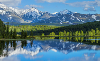 Wild mountain lake in the Altay mountains. Summer landscape, beautiful reflection. Travels in Russia.