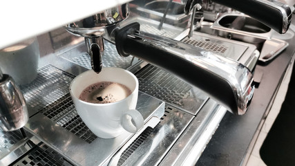 black coffee in white cup on coffee maker