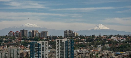Paisaje urbano de la ciudad de mexico, desde donde se ven los volcanes Iztaciuatl y Popocatepetl