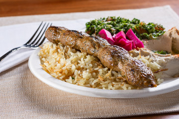 A view of a koobideh combo plate in a restaurant or kitchen setting.