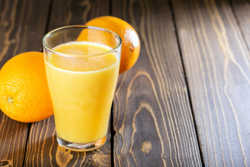 Fresh orange juice on wooden background with copy space.