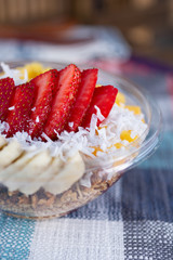 A closeup view of a strawberry acai bowl in a restaurant or kitchen setting.