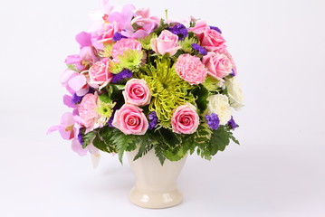 Colorful pink flower arrangement centerpiece with roses, lily, carnations, isolated on white.