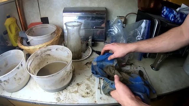 Extracting water from clay using a cloth in a home kitchen.