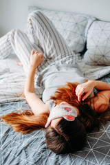 Sleeping habits. Woman in sleeping mask on the bed.