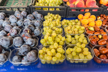 Various fruits sold in the market: plums and grapes