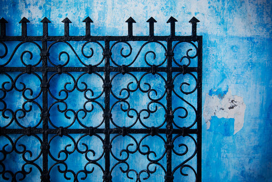 Metal gate against a blue wall in the medina of Rabat, Morocco